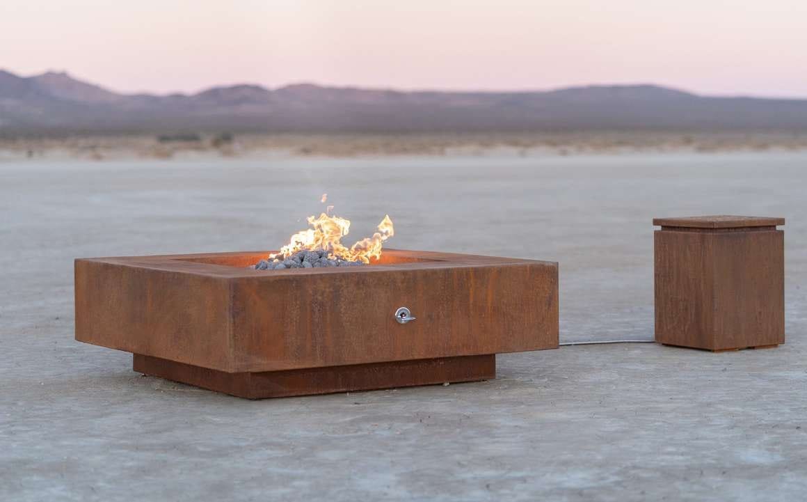 Bespoke corten fire tables on an open terrace at dusk