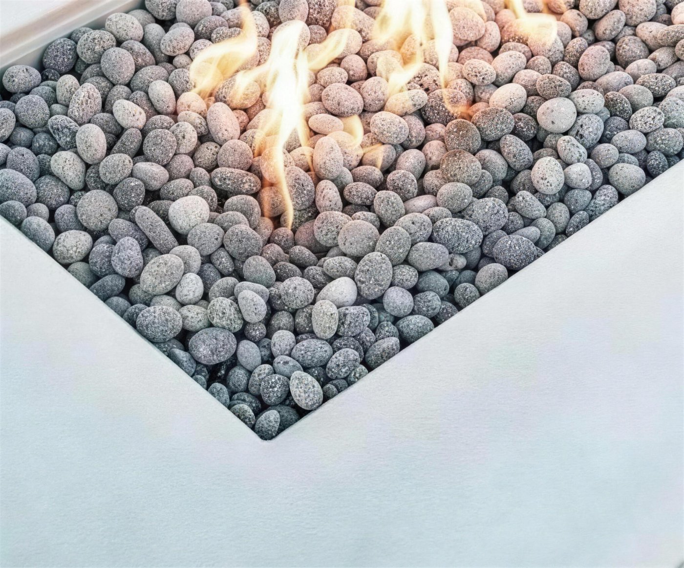 Pebble fire bed in an L-shaped fire table
