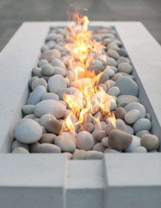 White pebble fire bed in a linear fire table