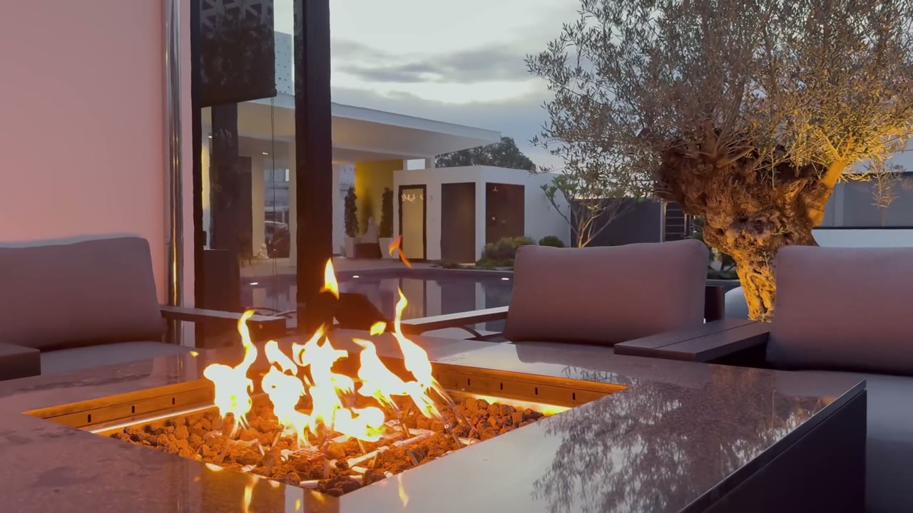 Bespoke fire table lit at a villa at dusk